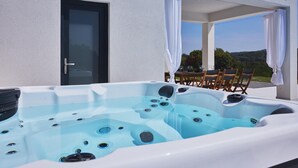 Ein Whirlpool mit Bedienfeld, einer Tür und einem Tisch mit Stühlen davor.