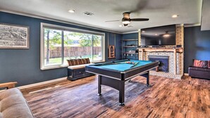 A pool table in a room with a fireplace, a television, and a large window. - Spacious Oasis, 5-bedroom house in Boulder with Views, 5.5 miles from Pearl St (Boulder)