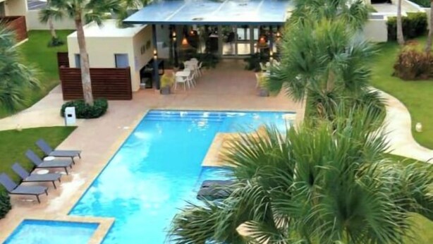 A pool area with lounge chairs and palm trees. - vr207h+c. Lovely apartment with pool view.

 (Bayahibe)