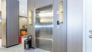 Un elevador moderno con acabados metálicos e iluminación empotrada en la pared.