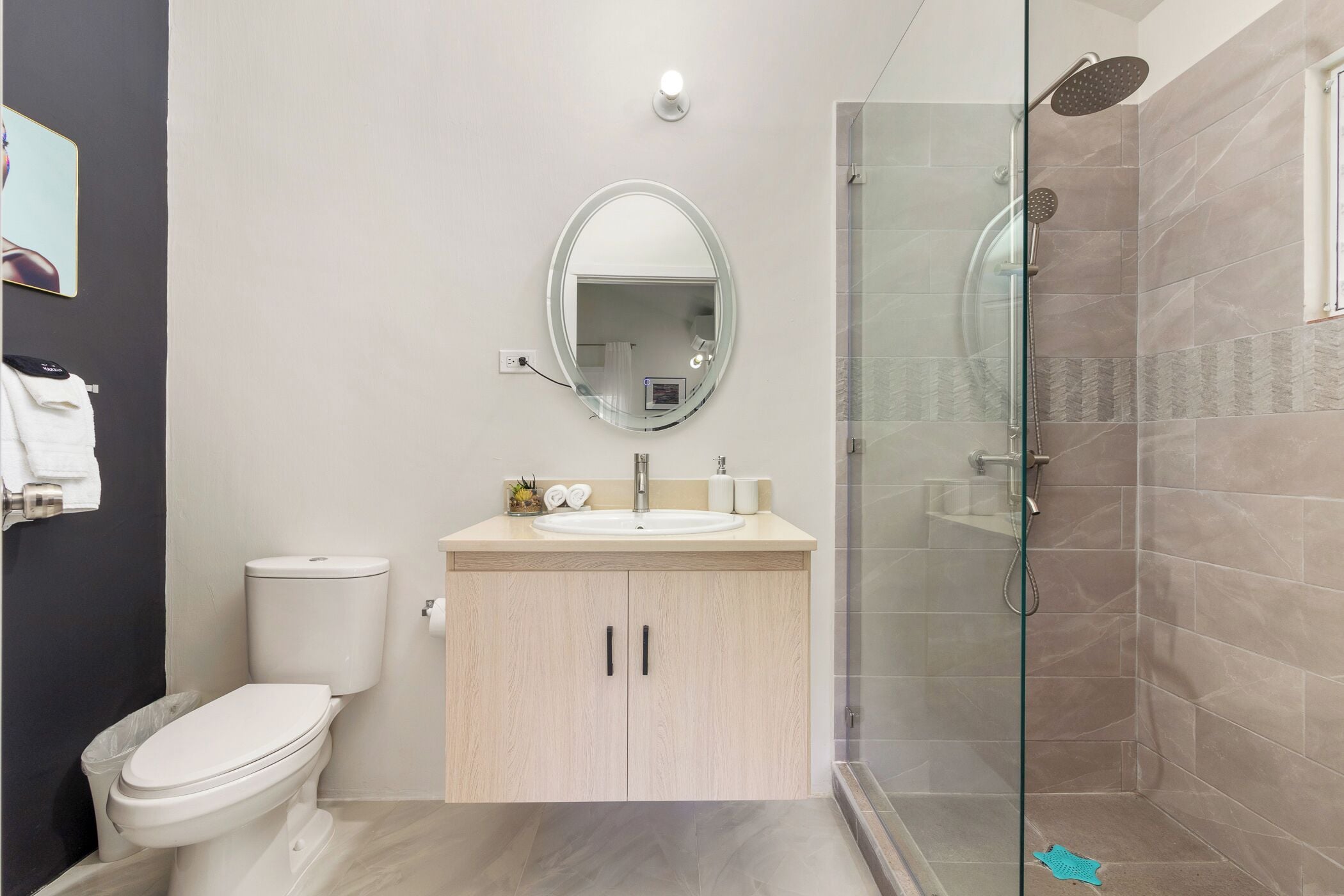 A modern bathroom with a toilet, sink, and shower.