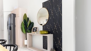 A reception area with a wooden desk, a round mirror, a welcome sign, and a potted plant. - Sunset at ArecaHomes~ Beach Access~ Pool & Water Park (Discovery Bay)