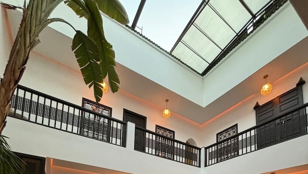 Un espacio interior amplio con piscina, asientos y un balcón.