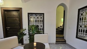 Un patio con un sofá, una mesa con vela y paneles decorativos.
