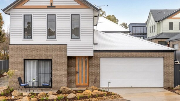 A two-story house with a garage, a patio with chairs, and a small garden. - Central Studio in new townhouse! (Beechworth)