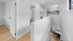 A modern interior with a staircase, a kitchen area, and a dining space. - New Central 2 bedroom townhouse! (Beechworth)