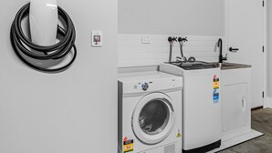 A laundry room with a washing machine, dryer, and a coiled power cord.