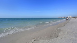 A beach with clear blue water and a sandy shore. - Beachfront paradise in this gorgeous renovated ground floor condo! (Marco Island)