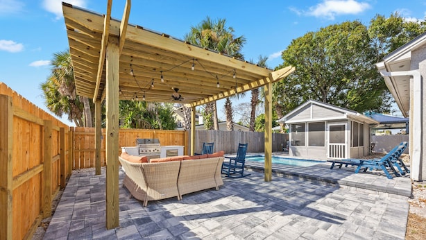 A backyard with a pergola, outdoor seating, a barbecue, and a swimming pool. - Beach Getaway w Pool | Good Morning Rentals (Jacksonville Beach)