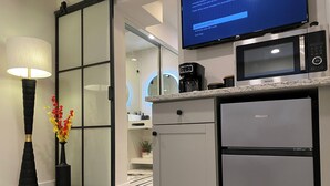 A modern kitchen with a built-in microwave, a coffee maker, and a refrigerator. - Luxury, Private Suite 2 (Palm Beach Gardens)