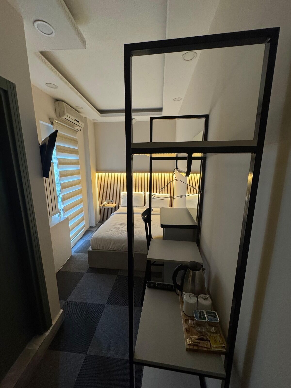 A compact hotel room with bunk beds, a desk, and a chair.