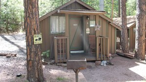 Eine kleine Holzhütte mit Tür, Fenster, Veranda und Briefkasten.