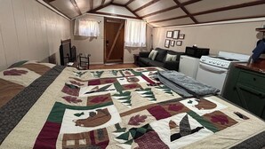 Ein gemütliches Schlafzimmer im Dachgeschoss mit einem großen Bett, einer Couch, einer Küchenzeile und einer Holzbalkendecke.