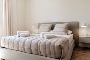 A neatly made bed with a striped bedspread, two pillows, and two bedside lamps. - CASA SOFIA - MyHomeinComo (Menaggio)