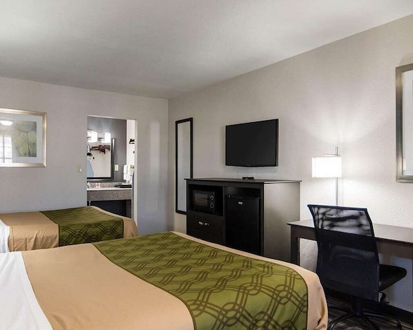 A hotel room with two beds, a desk, a television, and a mirror. - HomeStay Inn & Suites (Russellville)