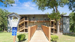 Un motel avec une passerelle en bois menant à un bâtiment doté de nombreux balcons.