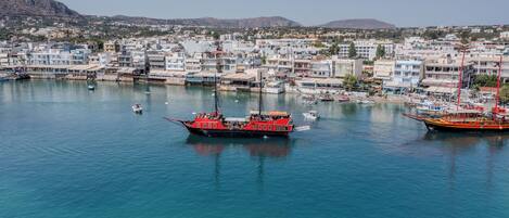 A harbor with boats, a red ferry, and buildings in the background.