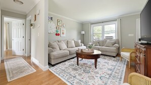 A living room with two sofas, a coffee table, and a large window.