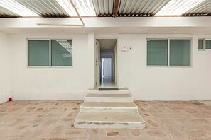 A room with a central staircase, white walls, and large windows. - Casa Ejecutiva Entera · 3 Suites Privadas · 5 min del Centro (Tlaxcala de Xicohténcatl)