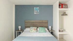 A bedroom with a bed, nightstands, a headboard, a wall-mounted shelf, and a framed picture. - Casa Ejecutiva Entera · 3 Suites Privadas · 5 min del Centro (Tlaxcala de Xicohténcatl)