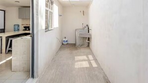 A narrow hallway with a window, a sink, and a water dispenser. - Casa Ejecutiva Entera · 3 Suites Privadas · 5 min del Centro (Tlaxcala de Xicohténcatl)