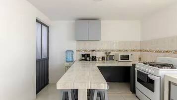 Een moderne keuken met een centraal eiland, inbouwapparatuur en een waterdispenser.