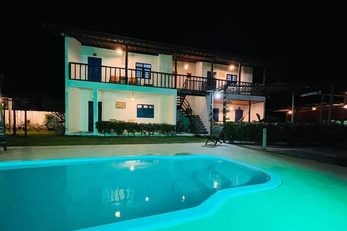 A swimming pool with a house in the background.