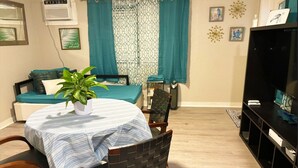 Un coin repas avec une table dressée pour deux personnes, une plante en pot et une chaise.