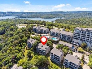 Un quartier résidentiel comprenant plusieurs immeubles d’appartements, une piscine et un lac en arrière-plan.