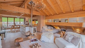 Una cabaña de madera espaciosa con comedor, cocina y sala de estar.