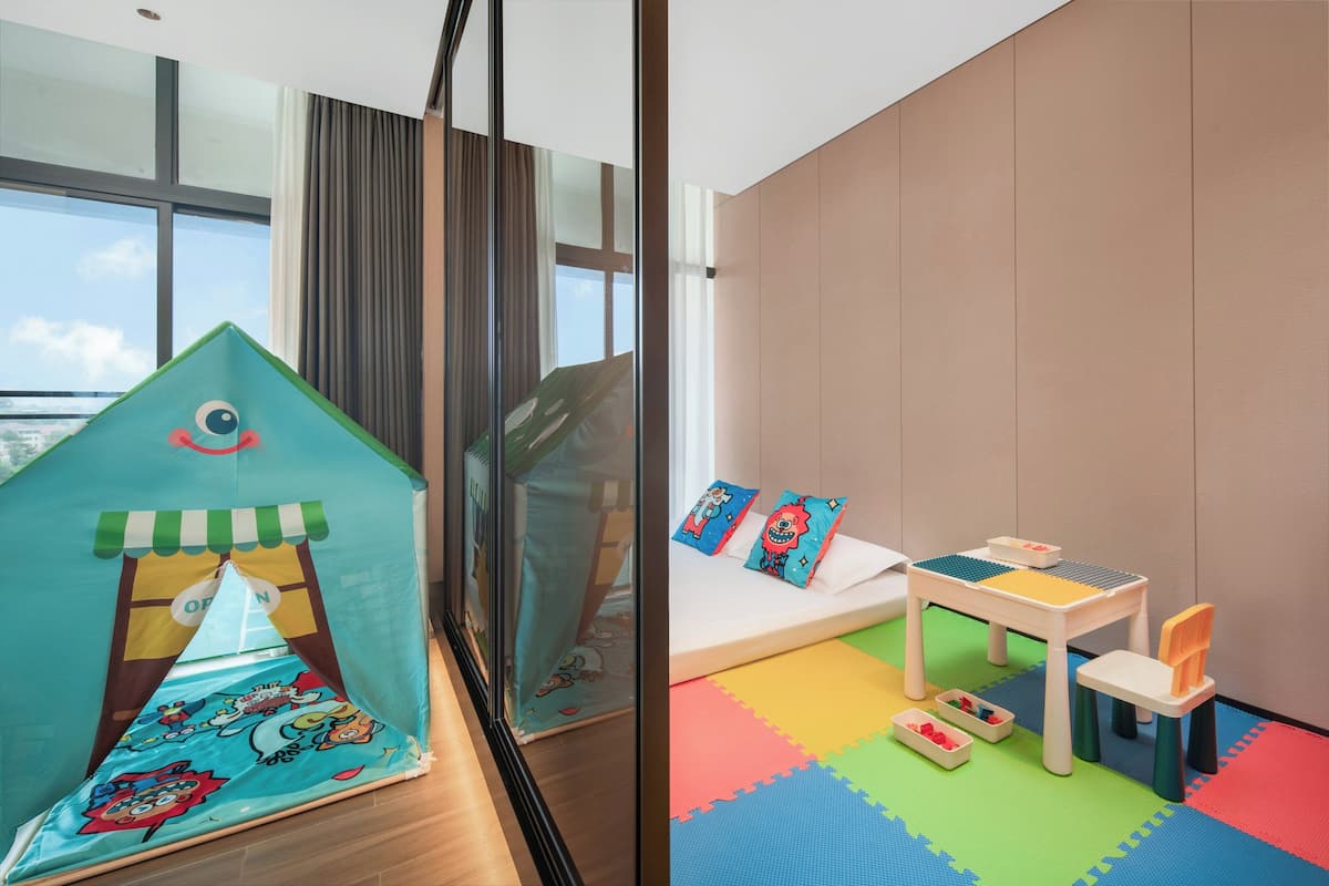 Ein Kinderspielbereich mit Zelt, kleinem Tisch und bunten Matten.