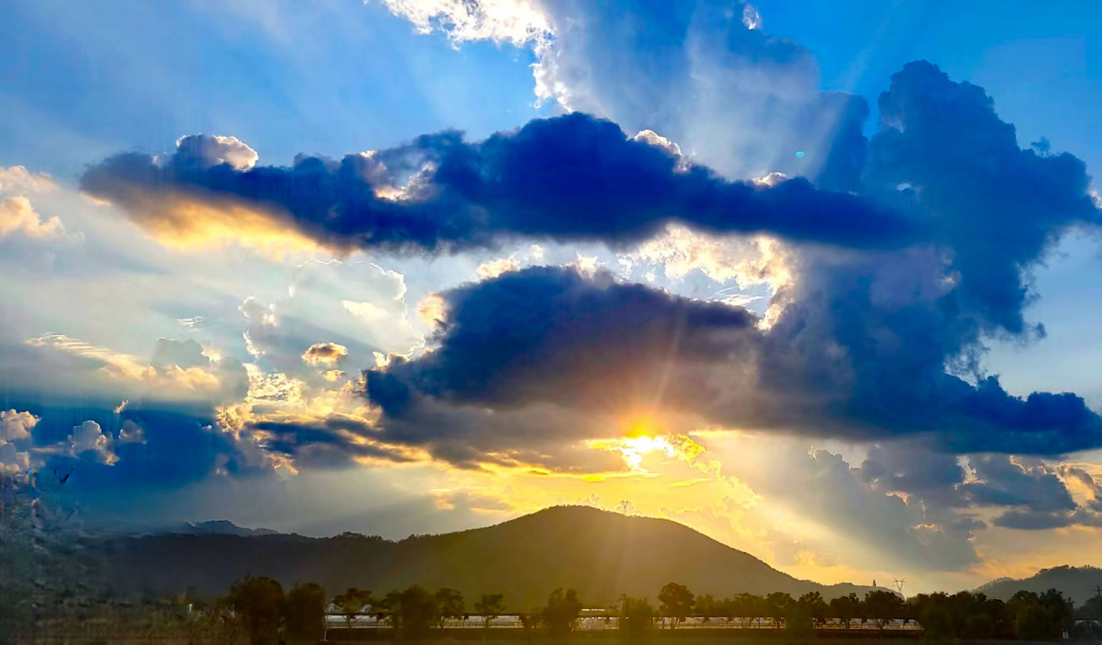 A mountain landscape with a sunset and clouds.
