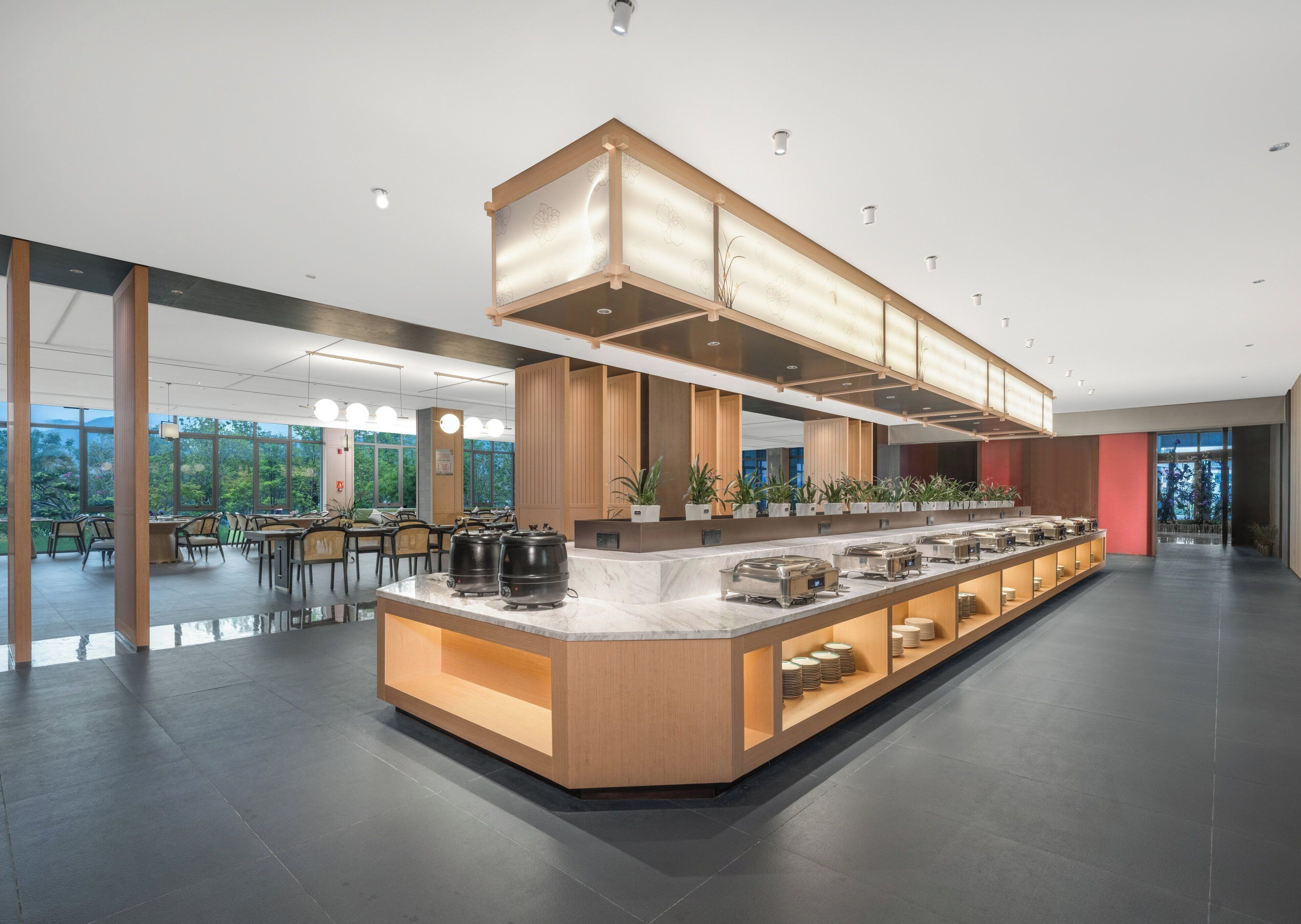 A modern kitchen area with a central island, built-in appliances, and a seating area with tables and chairs.