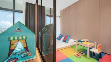 Un área de juegos infantiles con una carpa, una mesita y esterillas de colores.