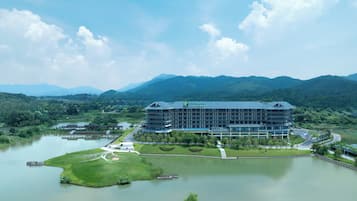 Ein Holiday Inn Hotel mit modernem Design, umgeben von einem See und Bergen.