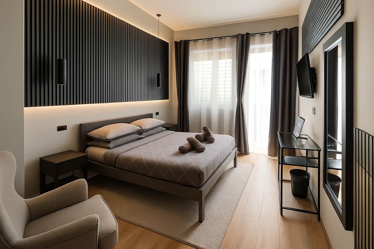 A modern bedroom with a bed, bedside tables, a chair, a TV, and a wall-mounted shelf.