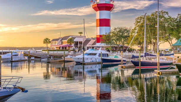 A marina with boats docked, a lighthouse, and buildings in the background. - Upscale Coastal Ranch ~ Private Pool & Spa ~ 13 Planters Wood Ct ~ Sleeps 10 (Hilton Head Island)