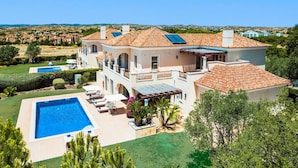 A large, two-story house with a swimming pool, multiple balconies, and a view of the surrounding landscape. - Villa Monte Rei Golf (Vila Real Santo Antonio)