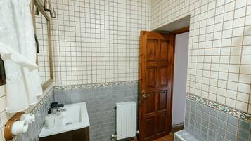 Un bagno con lavandino, WC e doccia.