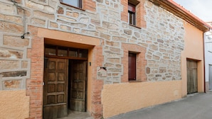 Ein Steinhaus mit einer Holztür und einem kleinen Fenster.