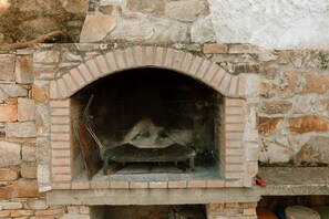 A stone wall with a brick fireplace. - La Lar Country House in Otero de Bodas with Outdoor Fireplace, Terrace, and Wi-Fi (Otero de Bodas)