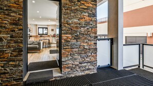 A modern interior with a stone wall, a kitchen area, and a view of the living space.