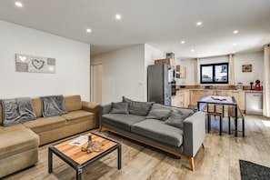 Un apartamento moderno con sala de estar, kitchenette y comedor.