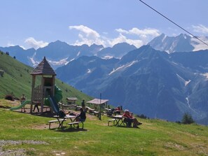 A playground with slides and tables, set against a backdrop of mountains. - 'La Casa Di Allegra' Apartment with Mountain View and Balcony (Vione)