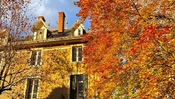 A two-story building with a symmetrical facade, large windows, and a visible chimney. - Studio Apartment 'Hyper-Centre Villa Isabelle' with Mountain View and Wi-Fi (Allevard)