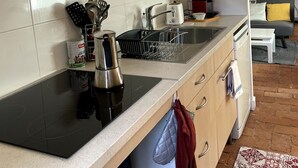 A kitchen with a stove, sink, and cabinets. There is a window with a view of the outside. - Studio Apartment 'Hyper-Centre Villa Isabelle' with Mountain View and Wi-Fi (Allevard)