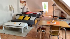 A cozy attic bedroom with a sloped ceiling, a bed, a desk, and a chair. - Studio Apartment 'Hyper-Centre Villa Isabelle' with Mountain View and Wi-Fi (Allevard)