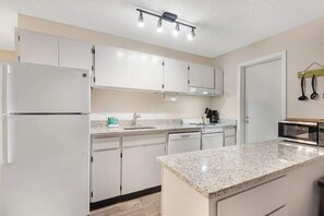 A modern kitchen with white cabinets, a granite countertop, and a built-in oven. - Riverfront Luxury In Downtown Bend. Pool/Hot Tub. (Bend)
