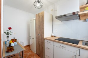 A kitchen with a wooden cabinet, a built-in stove, and a sink.