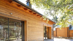 A wooden cabin with large windows, a deck, and a chimney. - Modern Family Chalet with Mountain View, Private Terrace and Wi-Fi (Bolquère)